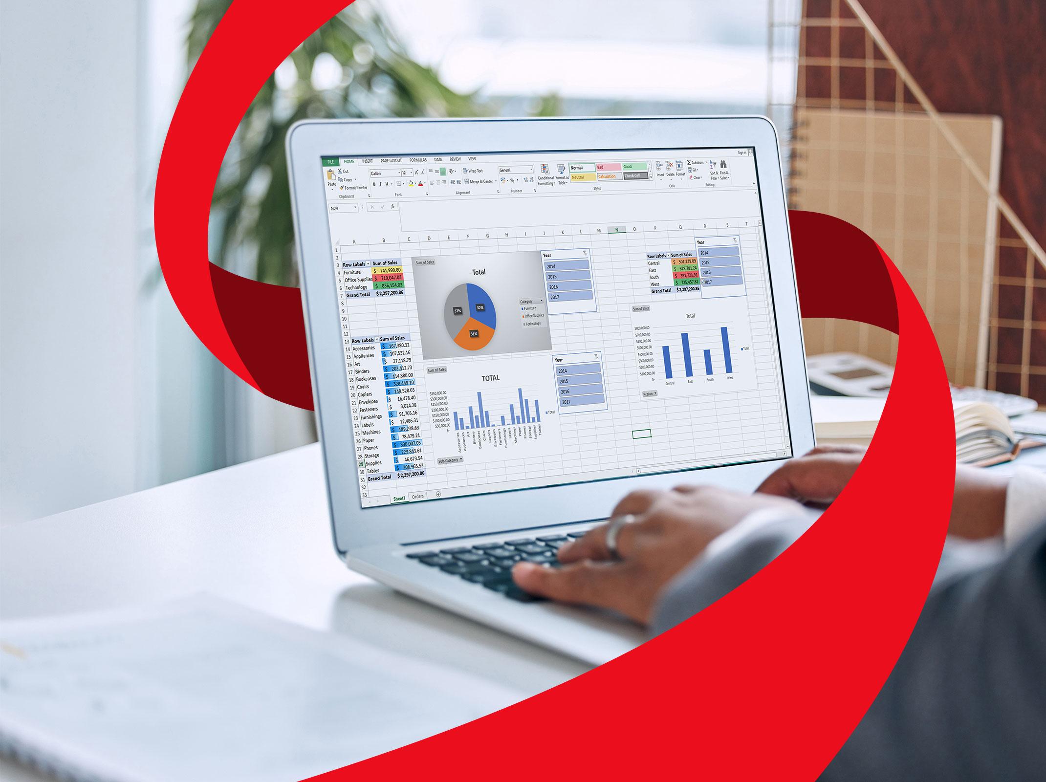 A business person working on a laptop.  On the laptop are Microsoft Excel graphs, charts and PivotTables.