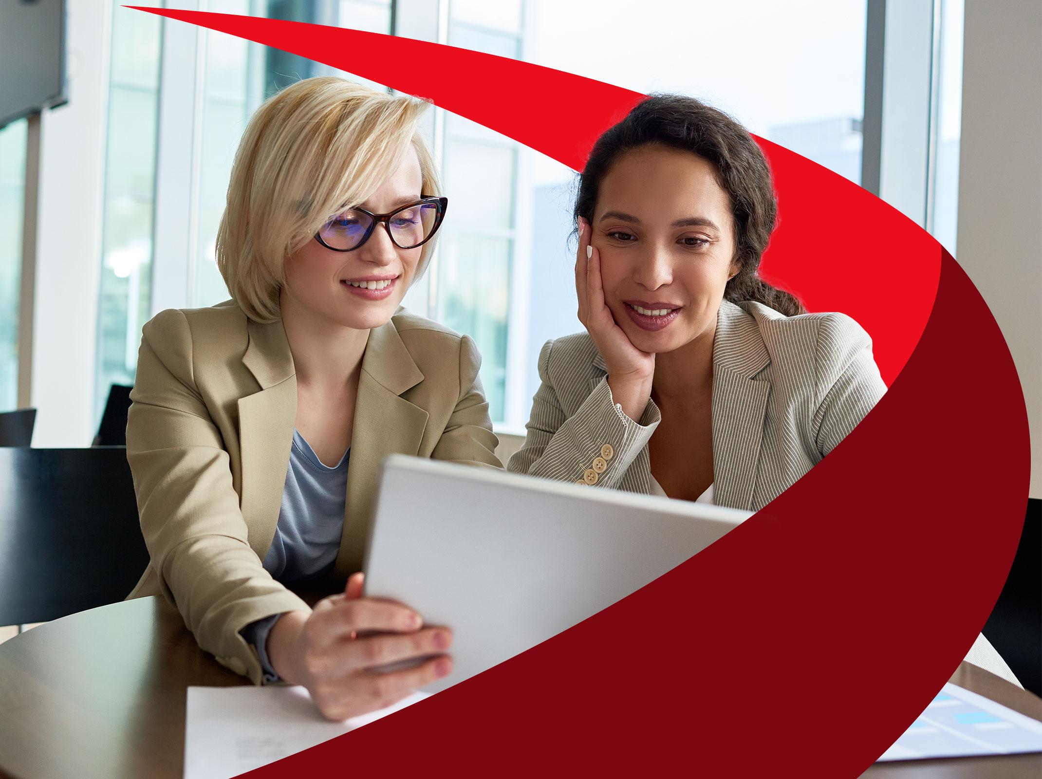 Two female leaders discussing something on a tablet